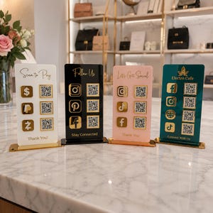 May include: Four rectangular acrylic signs in white, black, light pink, and dark green, each featuring gold-colored social media icons, payment symbols, and QR codes. The signs include text such as Scan to Pay, Follow Us, Let's Get Social, and Electro Cafe.