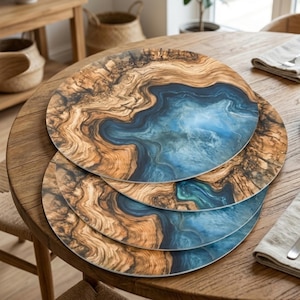 May include: Four round placemats with a wood grain and blue resin design. The placemats have a natural wood-toned border with a blue and white center, resembling a landscape. They are arranged on a wooden table.