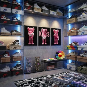 Pu&ograve; includere: Un'esposizione di sneakers e opere d'arte. Le sneakers sono in scatole sugli scaffali. Tre figure rosa KAWS incorniciate sono appese al muro. &Egrave; visibile anche una panca con il logo Supreme e un cuscino a fiori colorati.