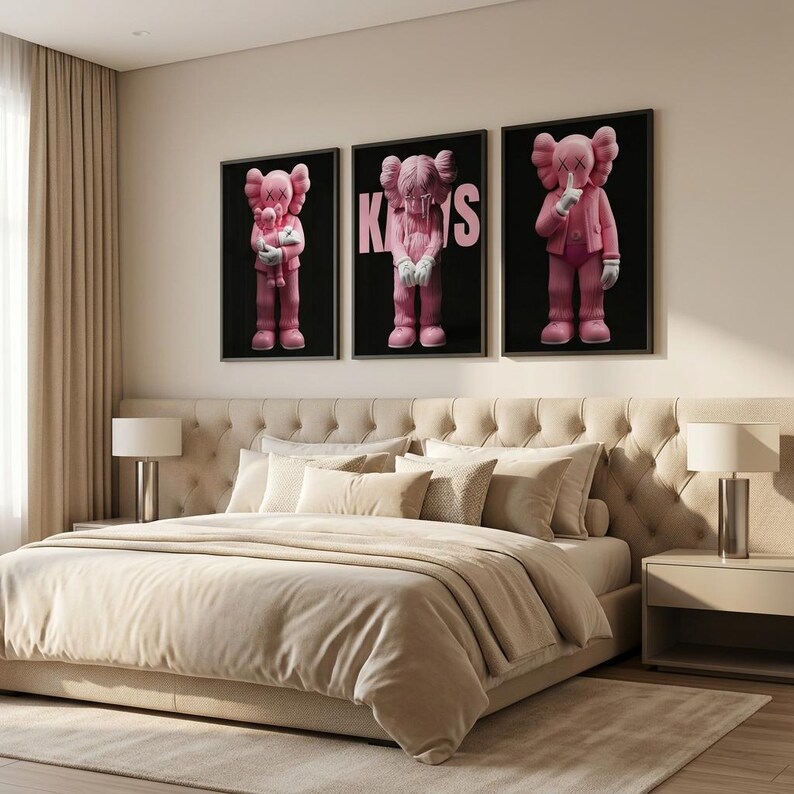 Pu&ograve; includere: Tre opere d'arte incorniciate con personaggi di cartoni animati rosa su sfondo nero. La camera da letto presenta un letto imbottito beige, comodini abbinati e una palette di colori neutri. L'arte aggiunge un tocco di colore alla stanza.