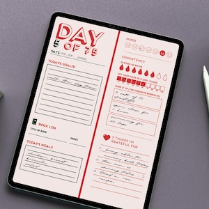 Op de afbeelding: Een digitale planner op een tablet met een rood en wit ontwerp, met secties voor dagelijkse doelen, maaltijden en het volgen van de stemming. Een witte stylus en een kleine vetplant in een witte pot liggen naast de tablet.