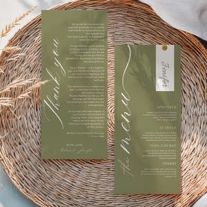 May include: Two olive green wedding stationery cards with white calligraphy. One card says "Thank you" and the other says "the menu" with a guest's name. The menu lists appetizer, starter, main course, and dessert options. The cards are on a woven surface.