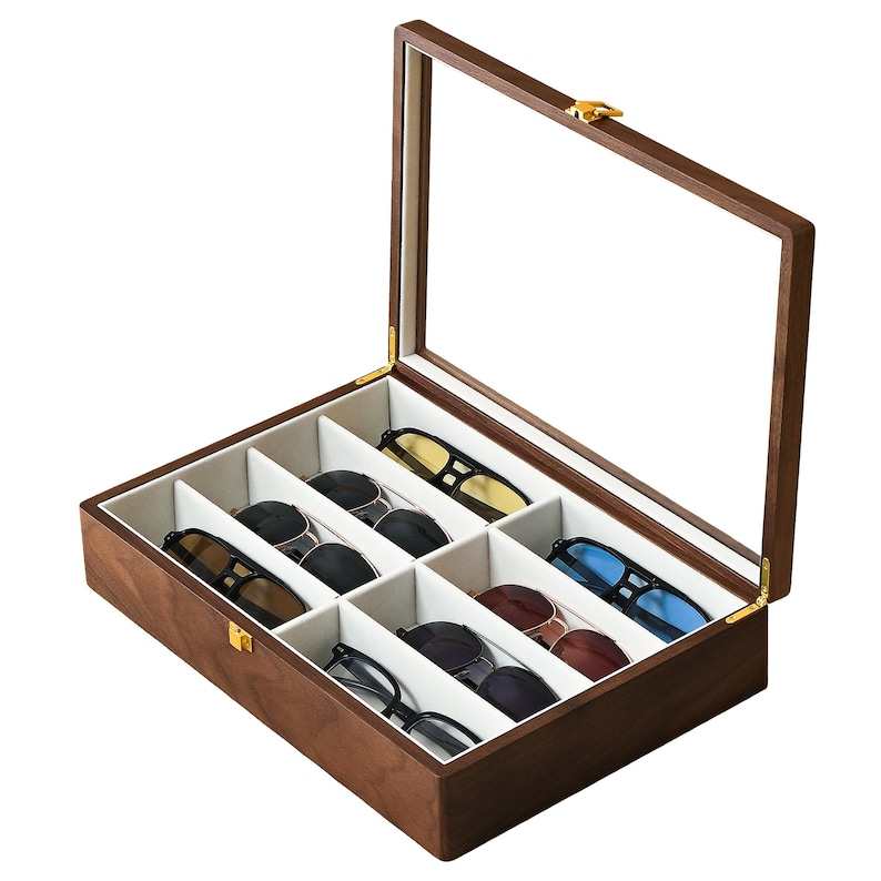 May include: A rectangular wooden storage box with a hinged glass lid and a gold-toned metal latch. The interior is lined with light beige fabric and divided into six individual compartments, each containing a pair of sunglasses with various frames.