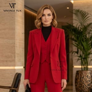 May include: A vibrant red three-piece suit consisting of a tailored blazer, a matching button-up vest, and trousers. The ensemble is worn over a black mock-neck top. The blazer features notched lapels and two side pockets. The brand logo Vintage Tux is visible.