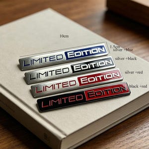 May include: Four rectangular metal badges with the text "LIMITED EDITION" in various color combinations: silver and blue, silver and black, silver and red, and black and red. Each badge is approximately 10 cm long and 1.5 cm wide.
