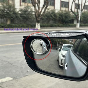 May include: A car side mirror with an attached backup blind spot mirror. The blind spot mirror is round with a chrome frame. The text "backup blind spot mirror" is visible.