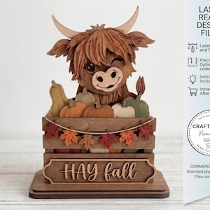 以下が含まれることがあります： 木製のハイランド牛の置物。カボチャが入った木箱と「HAY fall」の文字。置物は笑顔で、秋の葉に囲まれています。デザインはレーザー対応で、SVGファイルとPDFファイルが含まれています。