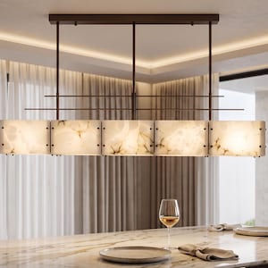 May include: A rectangular linear pendant light fixture featuring five translucent, cream-colored panels with dark veining, suspended by a dark metal frame with horizontal bars, providing soft illumination over a dining area.