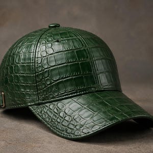 May include: A green baseball cap with a textured, crocodile-like pattern. The cap features a curved brim and an adjustable strap with a metal buckle. The cap is a solid, dark green color.