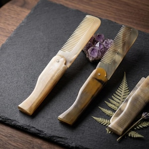 May include: A set of three ceramic mugs with a speckled, matte finish in cream, light grey, and dark grey. Each mug has a simple, minimalist design and a rounded handle. The mugs are suitable for coffee or tea.