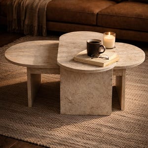 Peut inclure: Une table basse en deux parties avec une finition beige clair semblable &agrave; de la pierre. Un livre, des lunettes et une tasse de caf&eacute; sont pos&eacute;s sur la partie sup&eacute;rieure. Une bougie allum&eacute;e dans un support en verre est &eacute;galement sur la table.