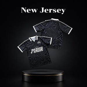 Peut inclure: Deux chemises noires à manches courtes avec un col blanc et un motif ondulé de style topographique en gris foncé. La chemise avant présente le texte "MAUR" dans une police blanche stylisée avec trois étoiles au-dessus. "New Jersey" est écrit.