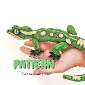 Puede incluir: Un juguete de gecko tejido a ganchillo en verde y crema con ojos grandes y una cola larga. El texto Crochet PATTERN Sarasinorum gecko está impreso en letras verdes y negras sobre la imagen. El gecko presenta una superficie texturizada.