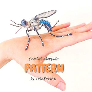 Puede incluir: Un mosquito de ganchillo hecho a mano con un tórax gris, un abdomen segmentado en azul y negro, y patas finas a rayas. El texto Crochet Mosquito PATTERN by TotaKsusha aparece en letras negras y naranjas en la parte inferior.