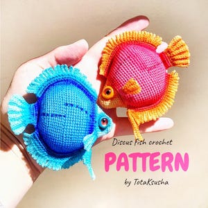 Puede incluir: Dos peces disco tejidos a ganchillo, uno en azul brillante y el otro en rosa y naranja, con aletas texturizadas y ojos oscuros. El texto dice: Discus fish crochet PATTERN by TotaKsusha.