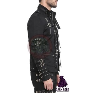 Op de afbeelding: Zwarte jas met meerdere zilveren gespen en ritsen. De jas heeft een hoge kraag en epauletten op de schouders. De mouwen hebben meerdere bandjes met zilveren gespen. De jas maakt deel uit van de gothic alternatieve modelijn.