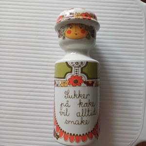 May include: A set of three ceramic mugs with a speckled, matte finish. The mugs are in shades of cream, light gray, and dark gray. Each mug has a simple, minimalist design and a rounded handle.