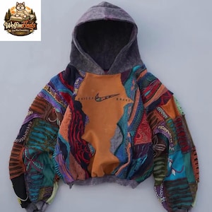 May include: A patchwork hoodie with a gray hood and a brown front panel featuring the Nike logo and the text "SNIDOSH BRAND". The sleeves are a mix of colorful fabric patches in various patterns and colors.