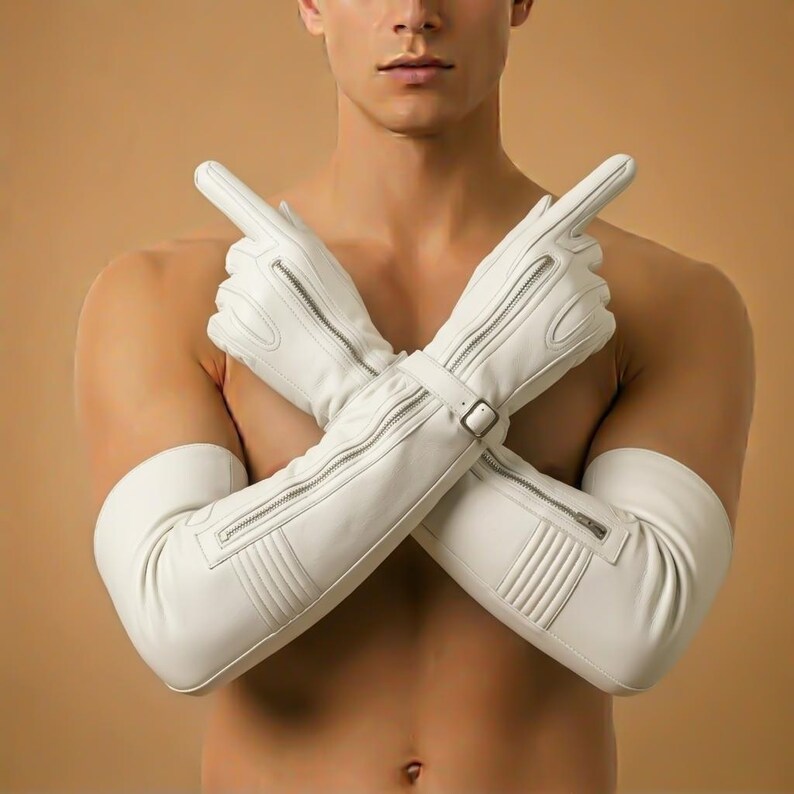 May include: White leather gloves with long sleeves, featuring silver zippers and a buckle closure. The gloves have a sleek, modern design with ribbed detailing on the upper arm.