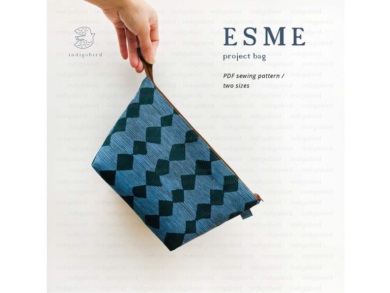 May include: A blue project bag with a diamond pattern and a brown handle. The bag has the text "ESME project bag" and "PDF sewing pattern / two sizes". The bag is held by a hand.