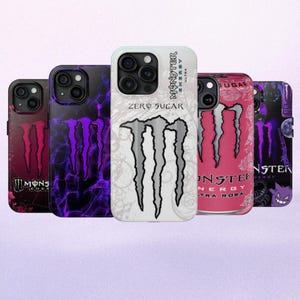 May include: A collection of phone cases featuring the Monster Energy logo and can designs. The cases display a variety of colors, including black, purple, pink, and white. Some cases have the text "ZERO SUGAR" and "ULTRA".