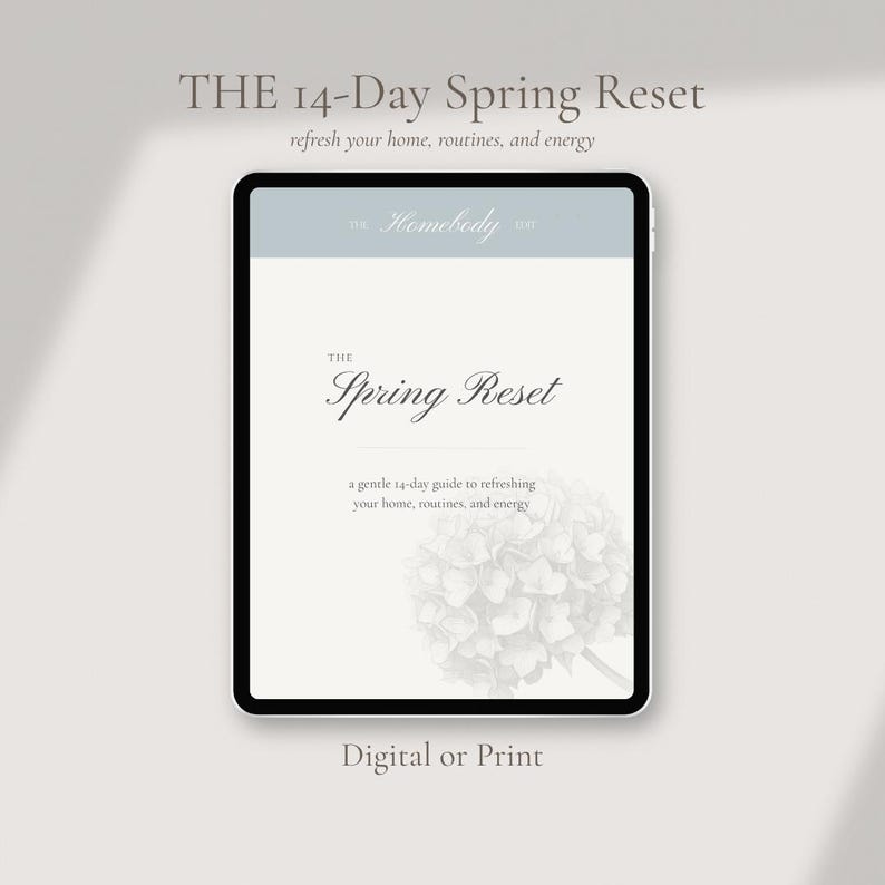 Op de afbeelding: Een digitale tablet toont "THE 14-Day Spring Reset" met de tekst "refresh your home, routines, and energy". Het scherm toont "The Spring Reset" en "a gentle 14-day guide to refreshing your home, routines, and energy". Onderaan staat "Digital or Print."