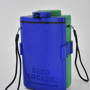 Puede incluir: Contenedores rectangulares azules y verdes con correas negras. El contenedor azul tiene las palabras "SEED LOCKER" y una dirección de sitio web impresa. Los contenedores tienen una tapa y están diseñados para guardar objetos pequeños.