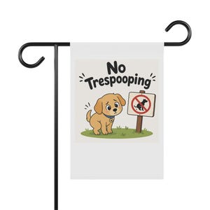 May include: A white garden flag with a black metal stand. The flag features a cartoon puppy next to a sign with a dog crossed out. Text on the flag reads "No Trespooping".