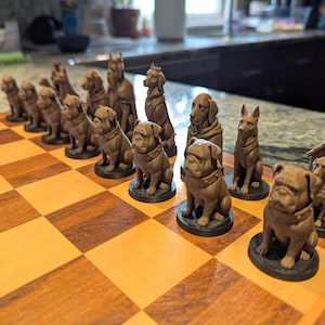 Pode incluir: Um jogo de xadrez castanho com peças em forma de cães. As peças incluem várias raças de cães, como pugs e dobermans, dispostas num tabuleiro de xadrez de madeira com um padrão xadrez castanho claro e escuro.