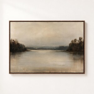 May include: A rectangular landscape painting in a dark brown frame depicting a calm lake under a muted, overcast sky. The scene features dark, silhouetted trees along the distant shorelines on both sides, with soft, neutral beige and gray tones.