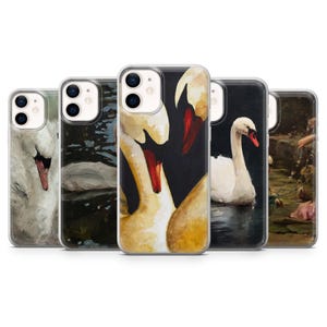 May include: A collection of five phone cases featuring swan artwork. The cases display paintings of white swans with red beaks, set against dark and water backgrounds. The art styles vary, showcasing different artistic interpretations of the swan theme.