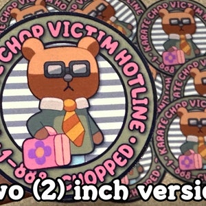 Puede incluir: Una pegatina redonda de 5 cm de di&aacute;metro con un oso marr&oacute;n de dibujos animados que lleva gafas y corbata. El oso sostiene una bolsa rosa con un dise&ntilde;o de flor. La pegatina tiene un fondo a rayas y el texto "KARATE CHOP VICTIM HOTLINE 1-888-CHOPPED." en letras rosa y negras.