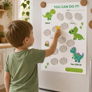 May include: A white dinosaur-themed reward chart with the text YOU CAN DO IT! and You Did It! featuring illustrations of green dinosaurs, a dinosaur egg, and grey stone-shaped spaces for stickers, with a line for a name and a reward section.
