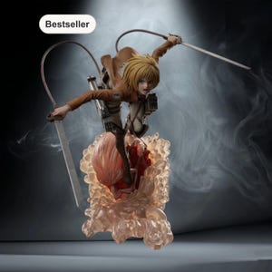 Op de afbeelding: Gedetailleerd beeldje van een personage uit de anime-serie Attack on Titan. De figuur is dynamisch geposeerd, houdt zwaarden vast, met een bruine jas en blond haar. De basis is een doorschijnende, wolkenachtige structuur. Het woord "Bestseller" staat in een witte ovaal.