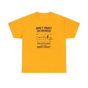 以下が含まれることがあります： マスタードイエローの半袖Tシャツ。黒い文字で「DON'T TRUST AN ENGINEER WHO SKIPS LUNCH THEY MIGHT SHORT-CIRCUIT」と書かれており、抵抗器と警告シンボルが描かれた電気回路図のグラフィックが添えられています。