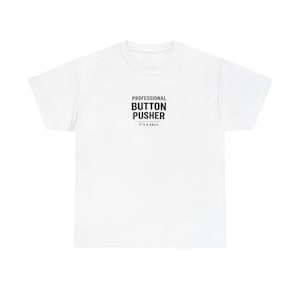 Op de afbeelding: Een wit T-shirt met korte mouwen en zwarte tekst in het midden van de borst met de tekst PROFESSIONAL BUTTON PUSHER, met daaronder de kleinere tekst IT'S A SKILL, vergezeld van twee horizontale lijnen boven en onder de kleinere zin.