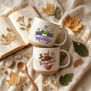 May include: Two speckled ceramic mugs stacked vertically. The top mug features a purple and green space ranger chest plate graphic with the text "to infinity". The bottom mug displays a brown cowboy hat and boot graphic with the text "and beyond".