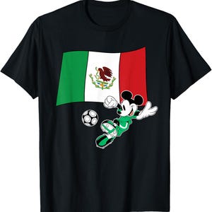 May include: Black t-shirt featuring a graphic of Mickey Mouse in a soccer uniform kicking a soccer ball. The Mexican flag is behind Mickey. The flag is green, white, and red with the Mexican coat of arms in the center.