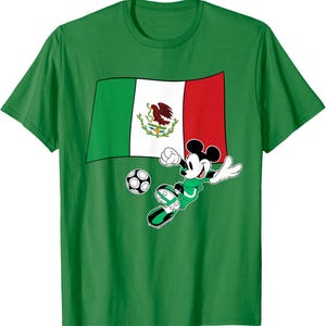 May include: Green t-shirt featuring a graphic of Mickey Mouse playing soccer in a green uniform. The design includes the Mexican flag and a soccer ball. The shirt is made of a soft material.
