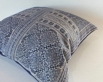 May include: A blue and white patterned throw pillow with a geometric design. The pillow is made of a soft, woven fabric.
