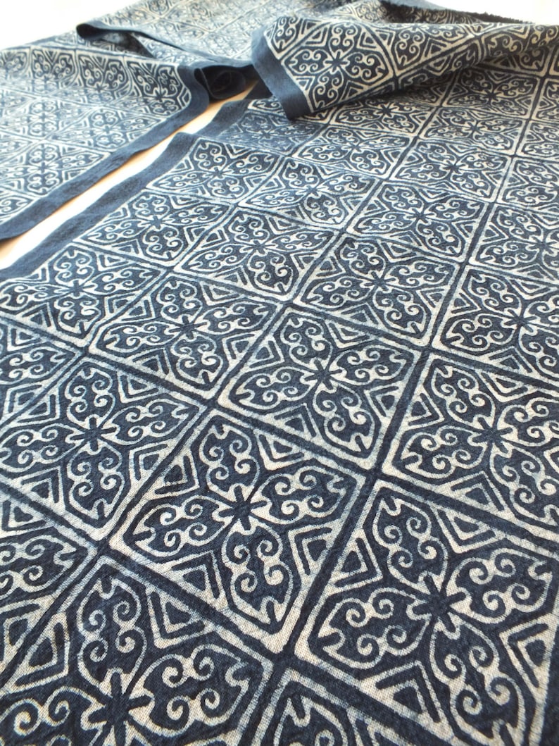 May include: A blue and white fabric with a repeating geometric pattern. The fabric is folded in half and the pattern is visible on both sides.