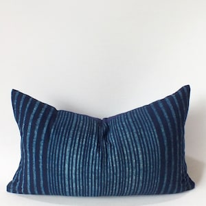 Peut inclure: Un coussin rectangulaire bleu et blanc à rayures avec un léger brillant. Le coussin a un design simple.