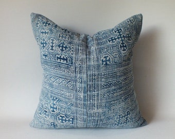 May include: A blue and white patterned throw pillow with a geometric design.