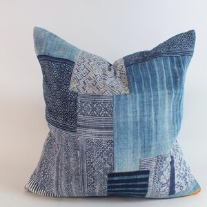 Könnte beinhalten: Ein blaues und weißes Patchwork-Kissenbezug mit geometrischem Muster. Der Kissenbezug ist aus weichem Baumwollstoff gefertigt und perfekt, um Ihrem Zuhause einen Hauch von Boho-Stil zu verleihen.