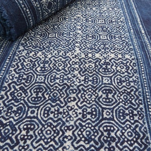 May include: A close-up of a blue and white fabric with a repeating geometric pattern. The fabric is folded in half and the pattern is visible on both sides.