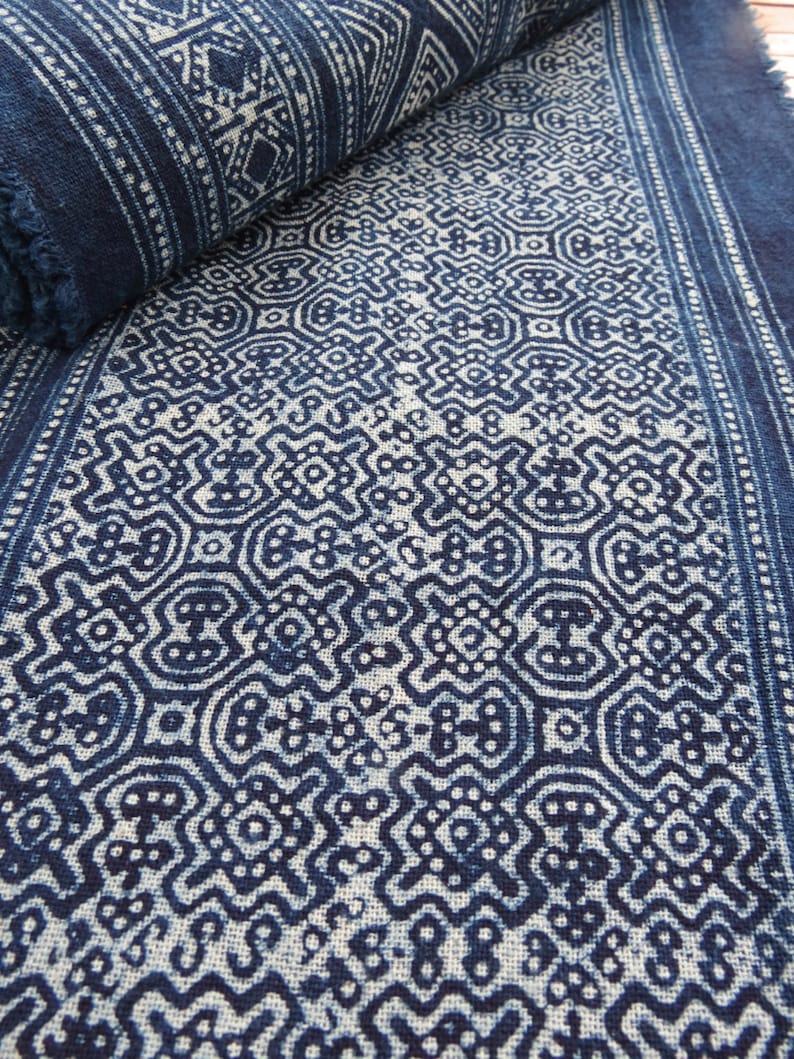 May include: A close-up of a blue and white fabric with a repeating geometric pattern. The fabric is folded in half and the pattern is visible on both sides.