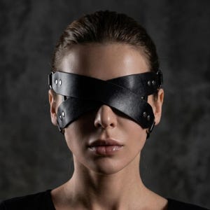 May include: A white ceramic mug with a black handle and the text "But first, coffee" in a black, handwritten-style font. The mug is on a white surface.