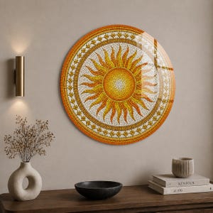 May include: A round mosaic art piece depicting a sun with yellow and orange hues. The sun design is surrounded by a decorative border with a glossy finish. The artwork is mounted on a neutral-colored wall.