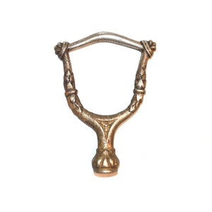 May include: A silver-toned metal hook with a decorative design. The hook has a curved top and a pointed bottom.