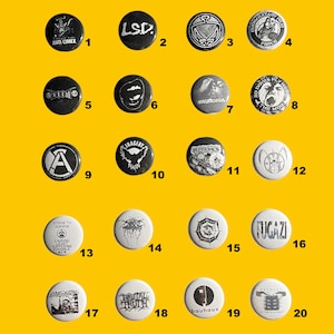 Puede incluir: Una colección de veinte botones redondos con varios diseños y textos, incluyendo logotipos de bandas y frases. Los botones son principalmente en blanco y negro, con algunos que presentan colores adicionales. Están dispuestos sobre un fondo amarillo.